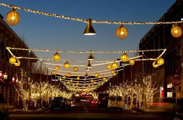 Street canopy of string lights and lanterns over a downtown block