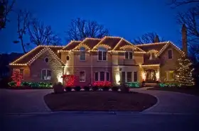 Large home with warm white roofline lights at dusk