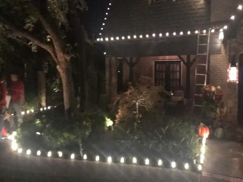 Pathway lights lining a front walk below a lit roofline at night